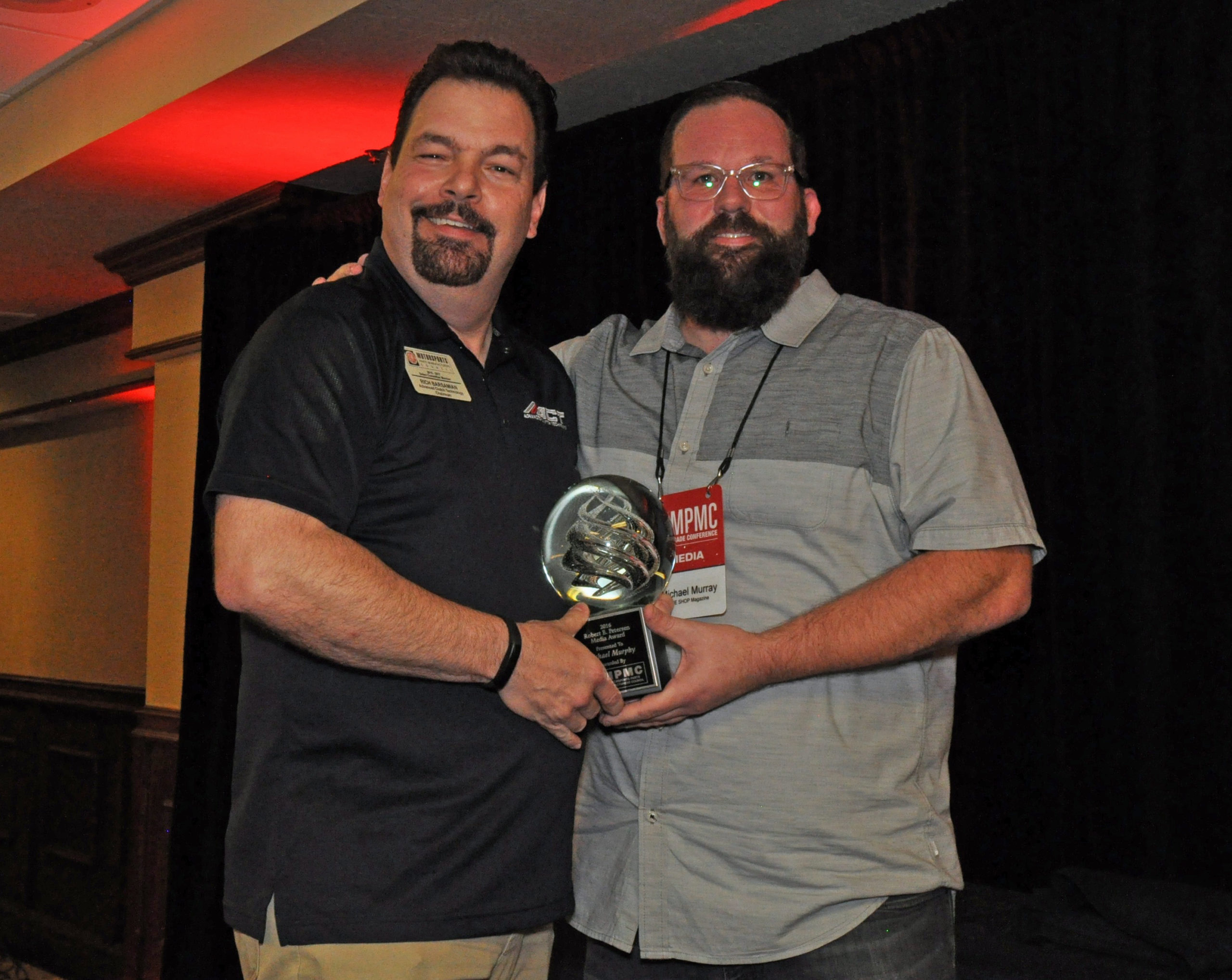 Michael Murray (right), associate publisher of THE SHOP magazine, accepts the Robert E. Pertersen award trophy from MPMC Chair R