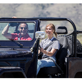 A young woman enjoys driving a classic Jeep at the Hagerty Driving Experience event on May 13 in Golden, Colorado