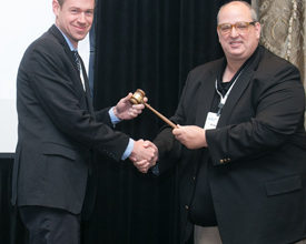 Immediate Past President Bob Holland (right) passes the gavel to new President Brian Herron.