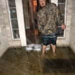 Josh Herzing gauges the high flood waters at a private residence near Houston
