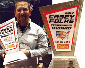 Jason Cobb stands with the Casey Folks Perseverance Award (left). The award is pictured in greater detail on the righthand side