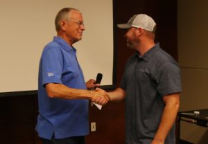 Steve Irby, founder of Stillwater Designs, congratulates Trevis Rakey for his 25-year anniversary with the company.
