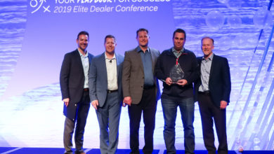 Josh Elliott (second from right), owner of Autoplex of Loveland, accepts the National Dealer of the Year award from Eastman Perf