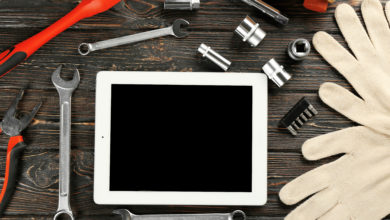 Tablet PC and tools for car repair on wooden table