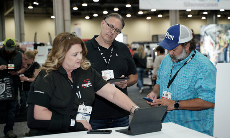 group of people looking at a computer at a trade show