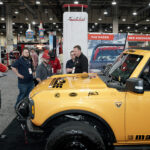 group of people talking on auto show floor
