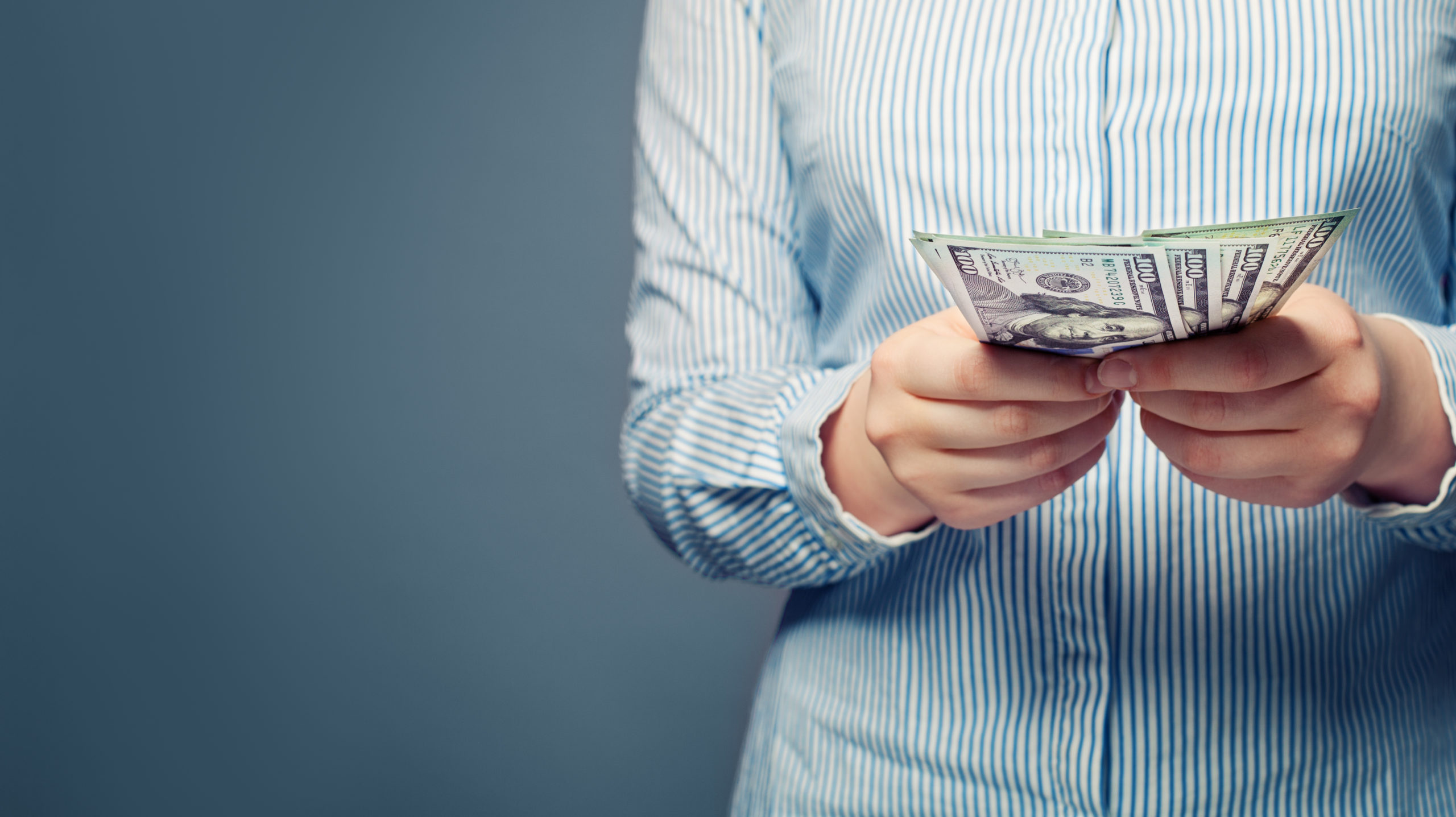 Hands counts money on blue background