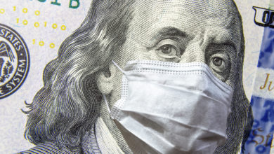 COVID-19 coronavirus in USA, 100 dollar money bill with face mask. COVID-19 affects global stock market. World economy hit by corona virus outbreak and pandemic fears. Crisis and finance concept.