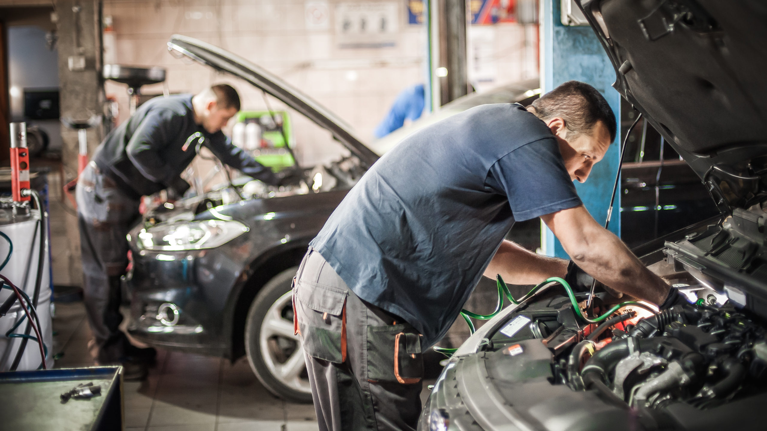 Car master auto mechanic repairer service technician checks and repairs the engine condition under the hood of the vehicle service shop