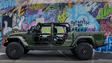 green modified truck in front of graffiti wall