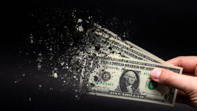 dollar bill disintegrating in man's hand
