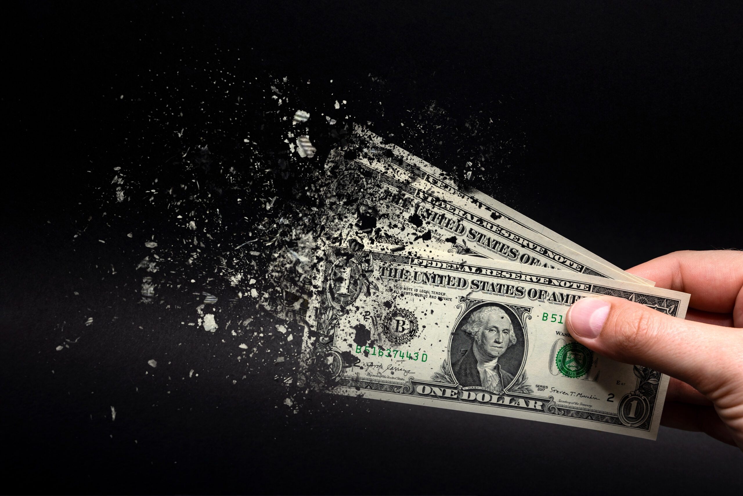 dollar bill disintegrating in man's hand