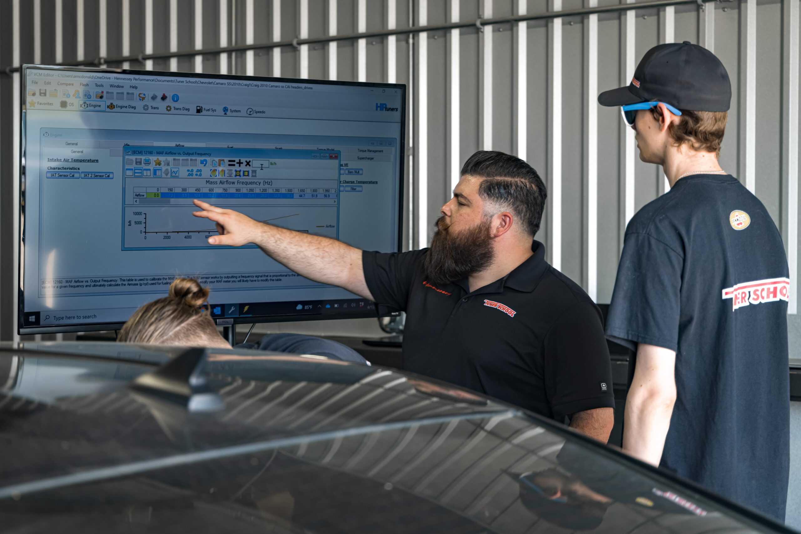 teacher pointing at screen showing data to student