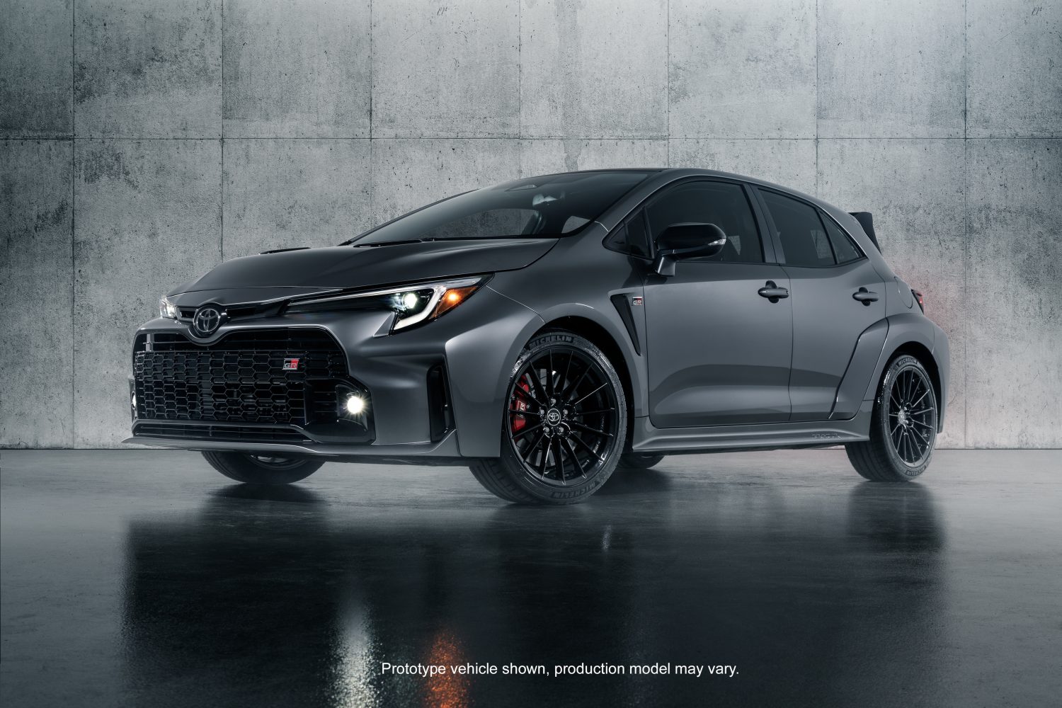 gray hatchback in front of concrete wall