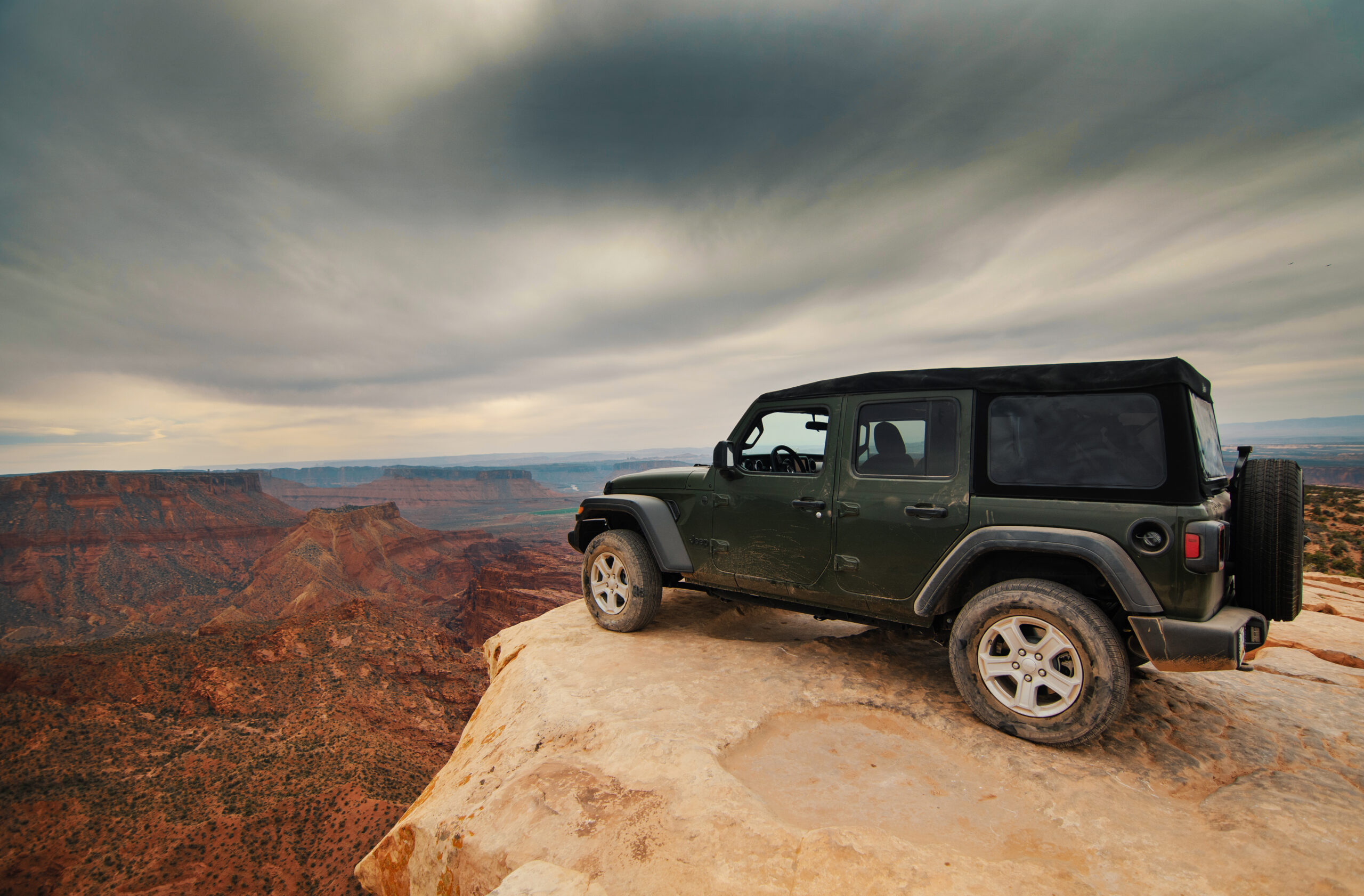 Jeep parked on a desert cliff.