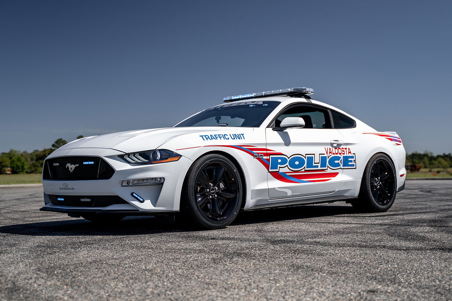 a mustang police cruiser sitting on the road