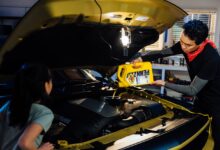 A father and daughter top off their car with Pennzoil motor oil.