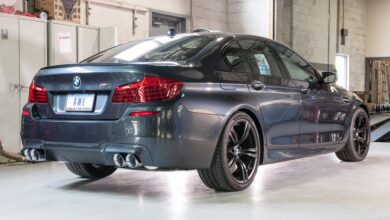 A rear view of a gray BMW M5 parked in a garage.