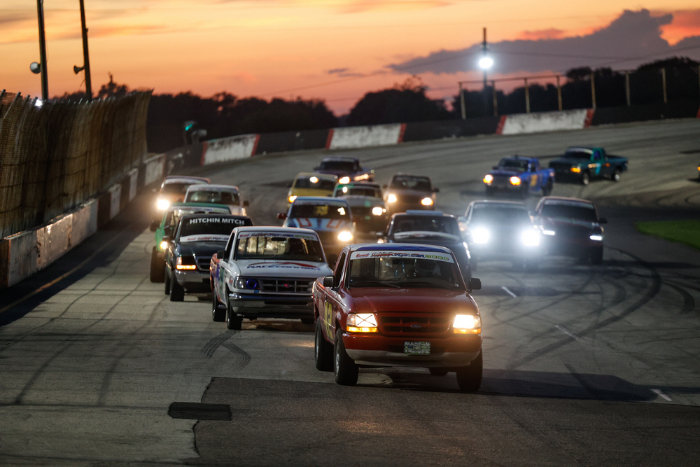 Cleetus & Cars race on track at dusk