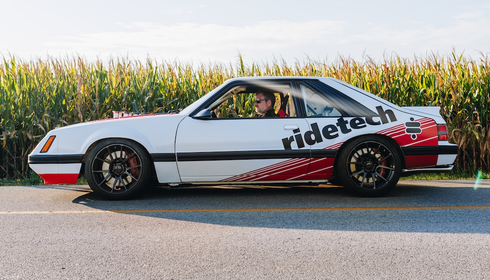 Ridetech white, red & black Mustang restomod in front of cornfield