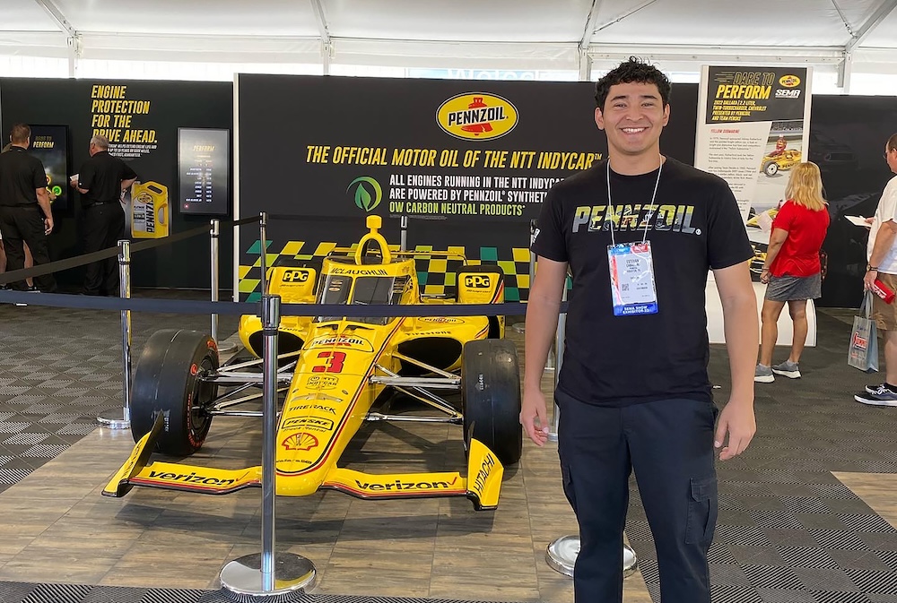 Estevan Caballero with yellow IndyCar at SEMA 2022