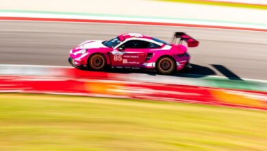 Pink Porsche race car navigates a turn