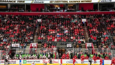 Detroit Red Wings players on the ice with crowd in background