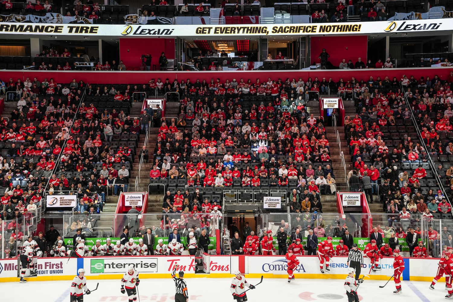 Detroit Red Wings players on the ice with crowd in background