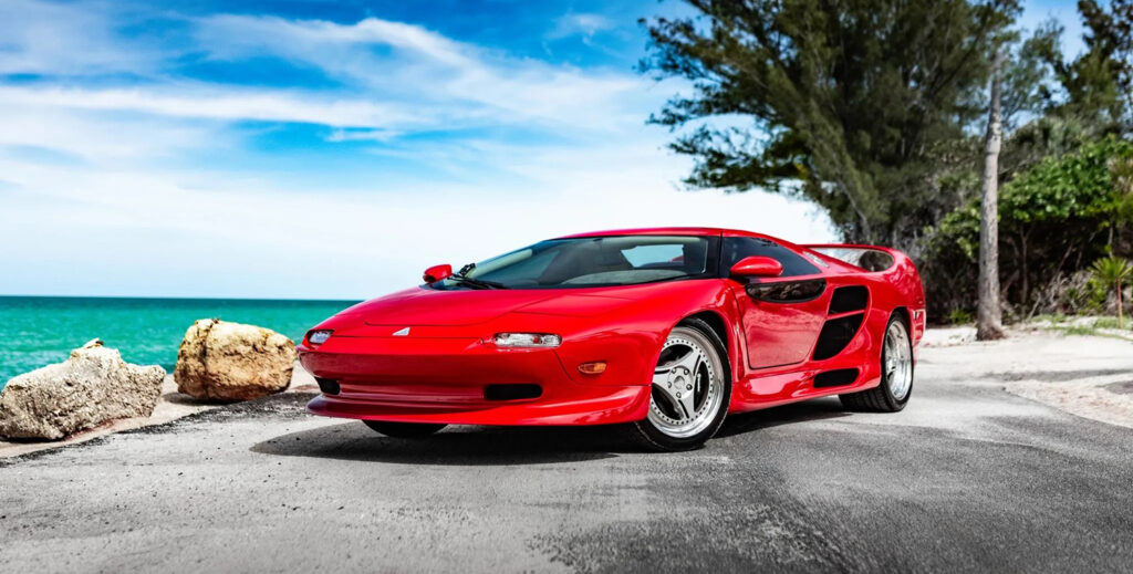 Red 1996 Vector M12 parked next to water