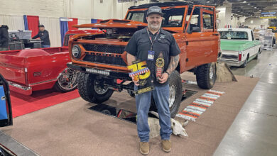 Jim McKay holding the TRIM Road Tour trophy in front of his 1972 Ford Bronco at the 75th Grand National Roadster Show