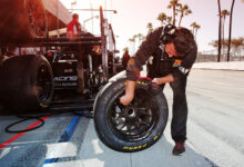 Pit crew member working on Pirelli tire