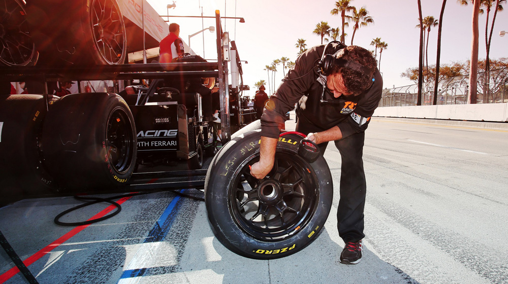 Pit crew member working on Pirelli tire