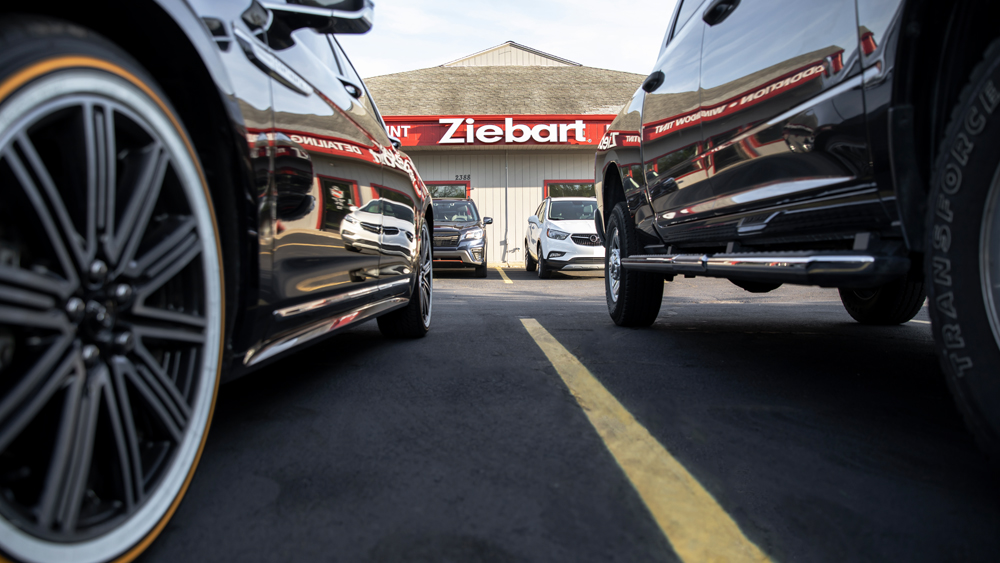 Two cars with Ziebart store in background