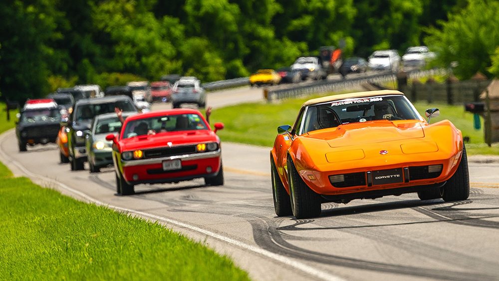 2024 hot rod power tour with a line of cars driving on road