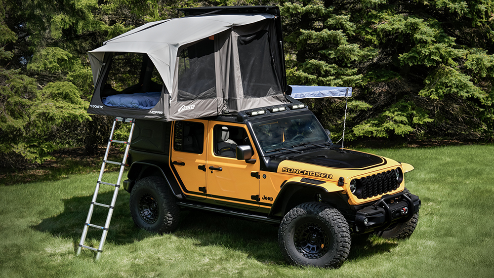 Awning and Rooftop Tent on Jeep Wrangler 4xe Sunchaser concept parked in front of tree line