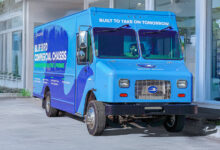 Blue Bird electric step van parked outside building