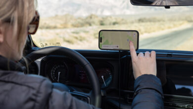 Person using smartphone mounted to dashboard