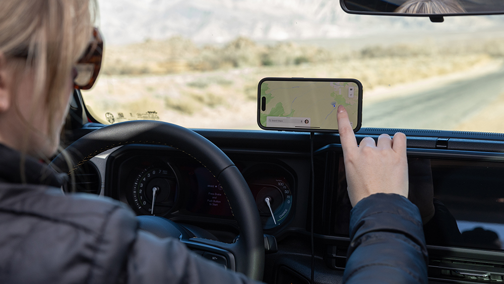 Person using smartphone mounted to dashboard