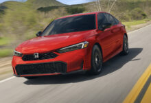 Red 2025 Honda Civic Sedan driving on road
