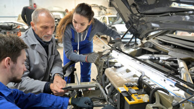 Instructor with trainees working on car engine