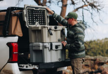 Person working with two Tuffy 75 Locking Dry-box stacked on tailgate of vehicle
