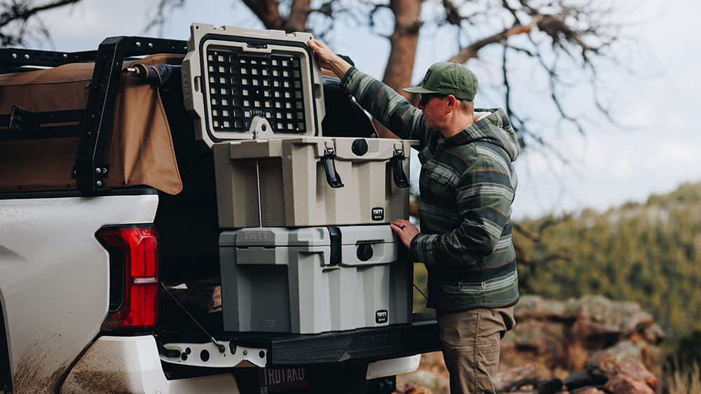 Person working with two Tuffy 75 Locking Dry-box stacked on tailgate of vehicle