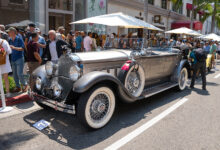 Vintage car surrounded by people at Rodeo Drive Concours d’Elegance