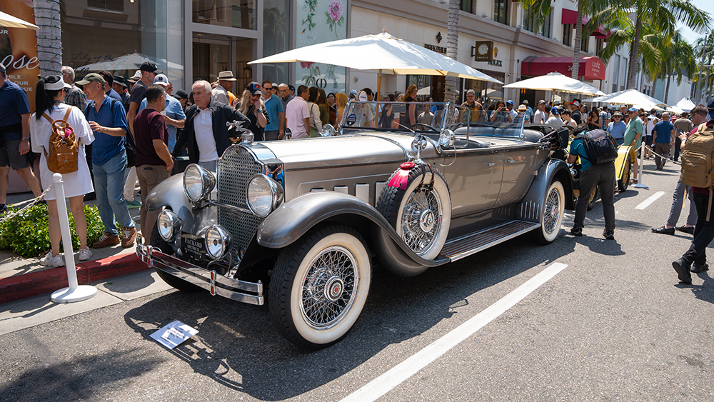 Vintage car surrounded by people at Rodeo Drive Concours d’Elegance