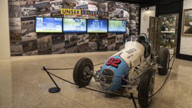 Vintage race car in front of Unser Collection video wall
