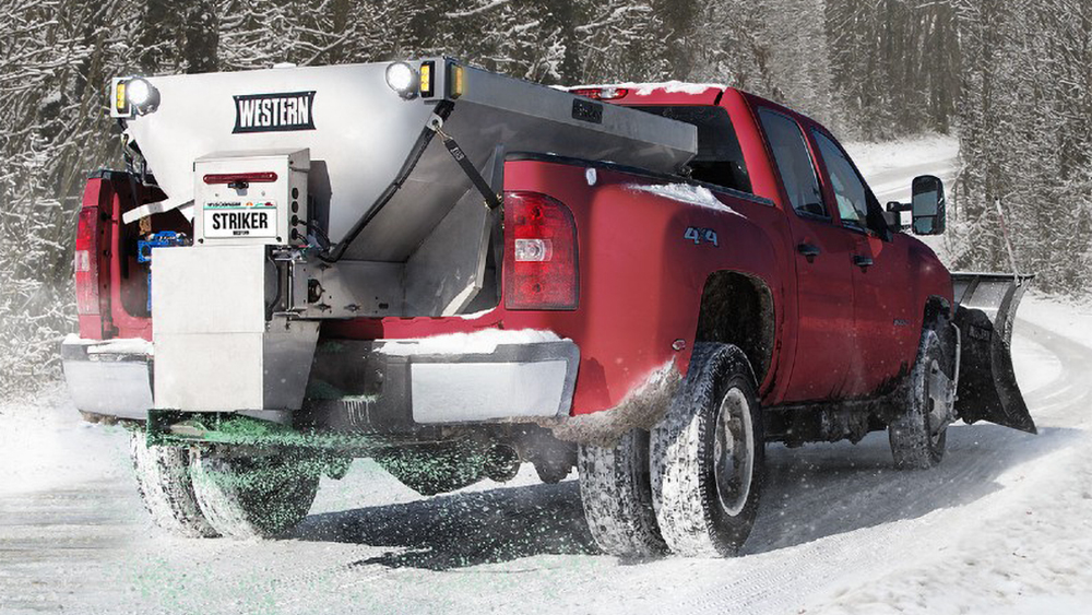 Truck outfitted with Western equipment on a snowy road