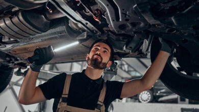 Professional auto mechanic working on the undercarriage of a car