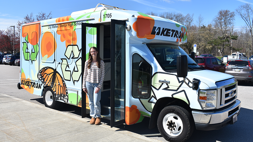 Avery Dennison - Mentor student Lily Walker poses with her winning bus wrap design 2025