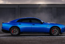 Blue 2026 Dodge Charger Daytona Sedan parked in front of wall at sunrise