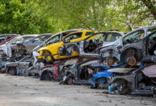 Car part salvage yard with rows of stacked wrecked cars